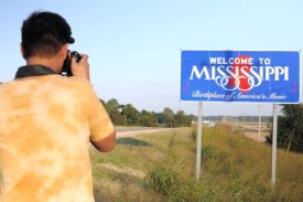 Baldwin Chiu taking a photograph of a Welcome to MIssissippi sign